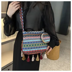 Detailed close-up view of bohemian ethnic large shoulder bag with colorful tassels on model