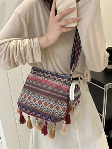 Detail view of an ethnic woven crossbody bag with tassels and a small matching pouch