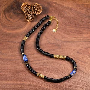 Detailed view of a vintage copper alloy and natural coconut shell necklace on wood