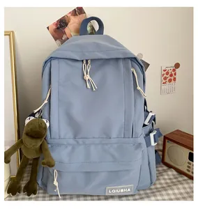 Detailed view of light blue Mori style school backpack featuring a cute green frog charm
