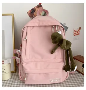 Minimalist pink school backpack for girls featuring a cute green frog plush charm