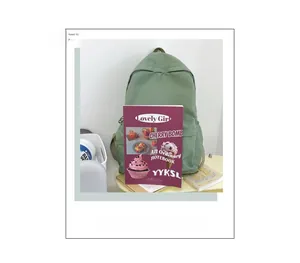 Größenvergleich eines grünen minimalistischen Rucksacks mit einem Notizbuch.