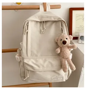 Minimalist beige backpack with a cute plush bear charm detail