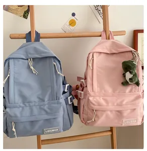 Detailed view of minimalist blue and pink school backpacks with a cute dinosaur charm