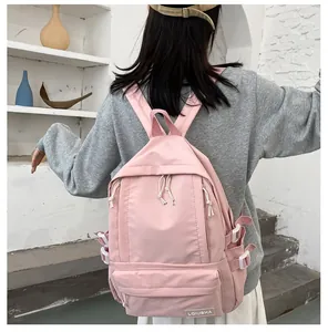 Back view of a pink minimalist school backpack worn by a student in a lifestyle setting
