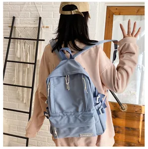 Lifestyle view of a light blue solid color aesthetic student backpack worn by a model.