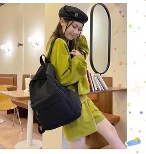 Modische Frau mit einem großen schwarzen Rucksack in einer gemütlichen Cafe-Atmosphäre.