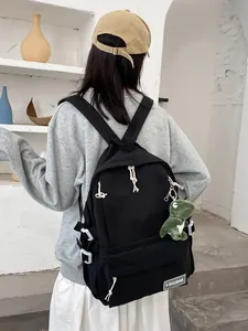 Minimalist black large capacity school backpack with cute green dinosaur charm pendant