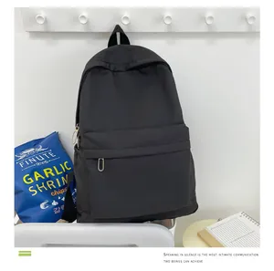 Minimalistischer schwarzer Rucksack mit großem Fassungsvermögen an einer weißen Wand