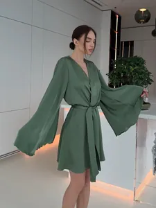 Peignoir élégant en satin vert avec manches évasées spectaculaires et ceinture à la taille.