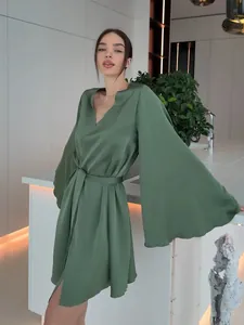 Détail de la robe luxueuse en satin vert sauge avec élégantes manches cloches