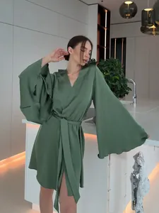 Peignoir court en satin vert élégant avec manches cloche à volants et ceinture assortie.