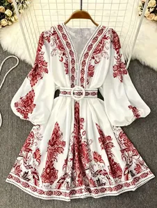 Detailed view of bohemian red floral print on white V-neck long sleeve dress with belt