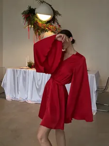 Peignoir élégant en soie rouge avec manches cloches surdimensionnées et bords à volants.