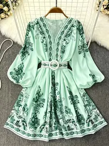 Detail view of mint green Bohemian print dress with V-neck and balloon sleeves.