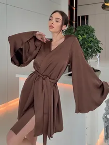 Gros plan d'un peignoir luxueux en soie marron avec d'élégantes manches évasées