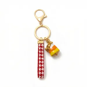 Portachiavi dorato alla moda con cinturino pied de poule e ciondolo candy corn per borse