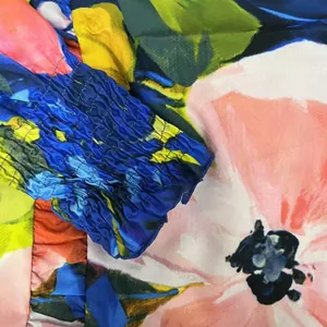Gros plan macro sur le poignet élastique smocké de cette robe à imprimé floral vif