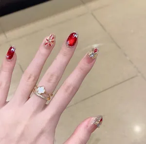 Luxury short oval press-on nails with red cat eye effect and rhinestone details