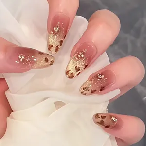 Detailed view of short oval press-on nails with nude glitter, rhinestones, and leopard print