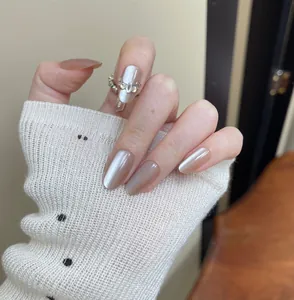 Elegant nude cat eye press-on nails with rhinestone accents on short oval shape nails.