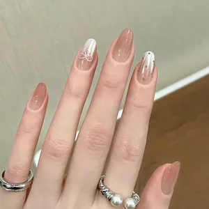 Elegant short oval press-on nails featuring a nude gradient finish with pearlescent bow detail