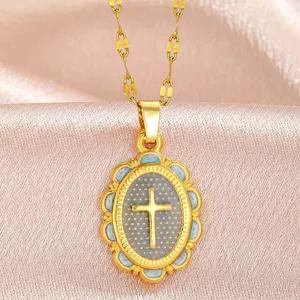 Detailed view of a vintage gold cross pendant with intricate borders on pink silk.