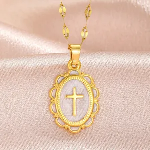 Close-up of a vintage gold-plated cross pendant featuring a textured oval medallion