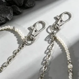 Dettaglio della chiusura a moschettone in argento su una catena da vita vintage con perle