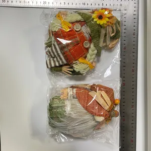 Two harvest-themed plush gnomes in plastic packaging with rulers for size