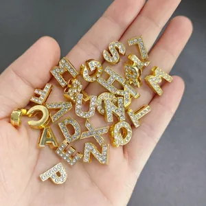 Close-up of 8mm gold rhinestone-studded alphabet beads for DIY jewelry crafting.