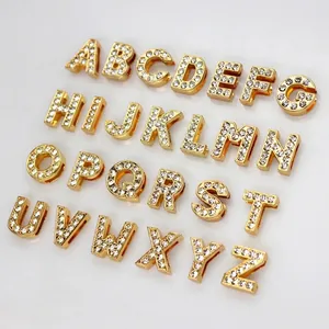 Macro detail of 8mm gold rhinestone alphabet beads for DIY jewelry making and bracelets.