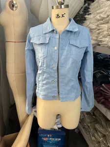 Detailed view of women's light blue denim jacket featuring flap pockets and silver buttons