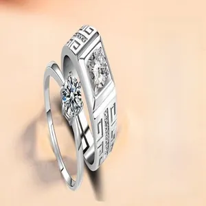 Close-up of couple's rings with zircon stones and adjustable silver-tone bands.