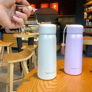 Macro view of minimalist thermos cup featuring a decorative leather tassel carrying strap