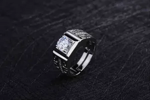 Close-up of a bold men's wide band ring with large cubic zirconia and silver finish.