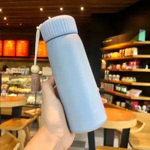 Close-up view of a pastel purple insulated water bottle featuring a decorative tassel.