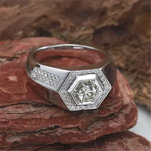 Detail view of a men's silver-colored hexagonal ring with sparkling zircon stones on wood