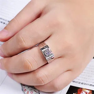 Close-up of a silver men's ring with square zircon on a finger