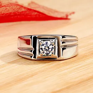 Close-up detail of a men's silver ring with a brilliant round zircon in a square setting.