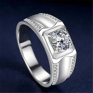 Close-up of elegant men's silver ring with central cubic zirconia and pave side stones.