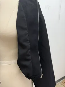 Detailed view of the soft black bomber jacket showing interior lining and zipper