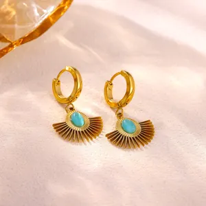 Close-up detail of luxury gold-plated sunburst hoop earrings with blue opal stone inlay