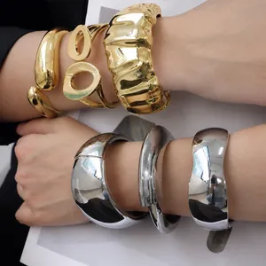 Gros plan de bracelets épais en alliage doré et argenté sur les bras
