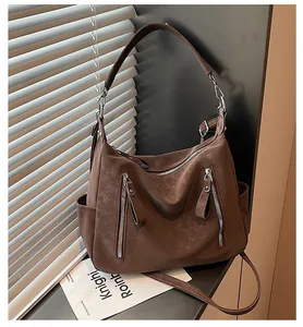 Detail of brown textured hobo bag with silver zipper accents and wide strap