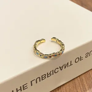 Close-up of vintage gold open ring with blue gradient enamel and ethnic patterns