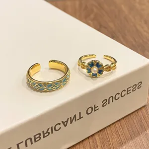 Detailed view of vintage gold rings with blue enamel floral and geometric patterns