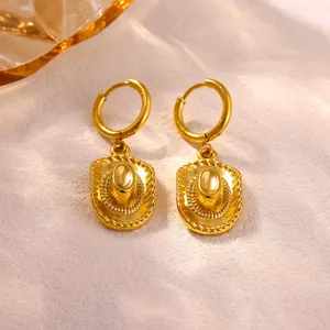 Detailed close-up of golden stainless steel hoop earrings with cowboy hat charms