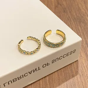 Detailed macro view of vintage style gradient blue enamel open rings displayed on a white book