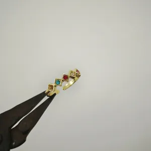 Vista dettagliata dell'anello dorato regolabile con cinque zirconi arcobaleno quadrati